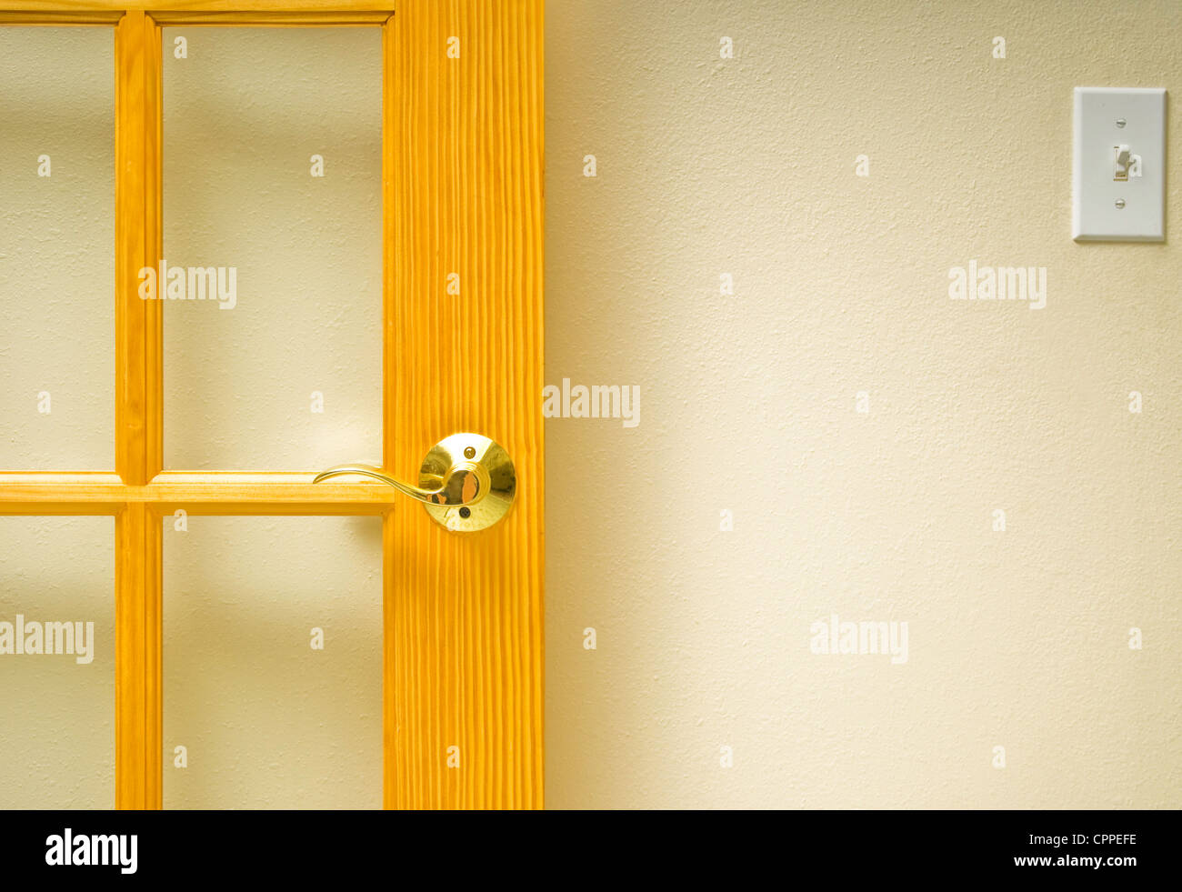 A section of wall with an open door and light switch Stock Photo