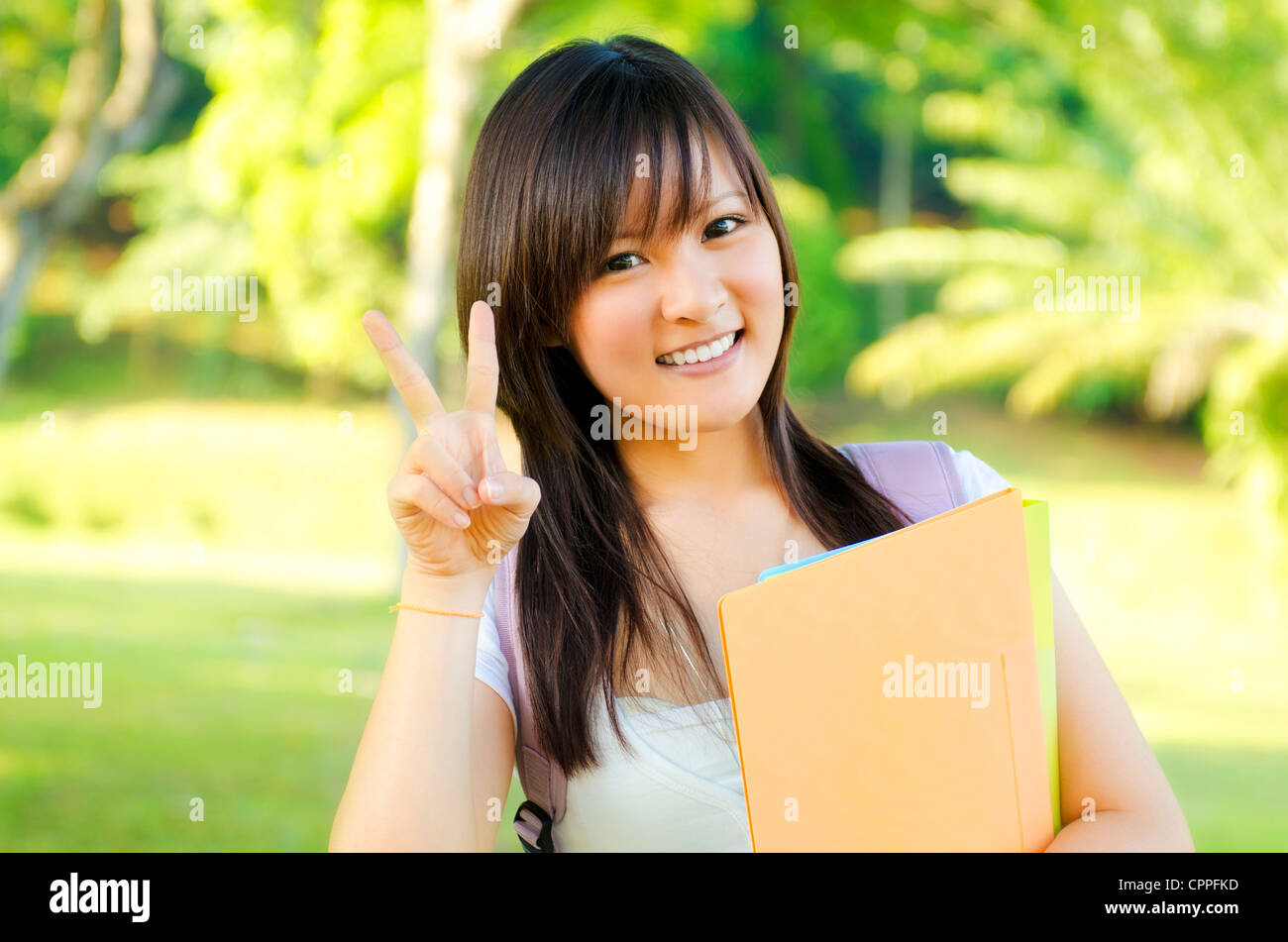 Cute teen with victory sign standing Stock Photo - Alamy