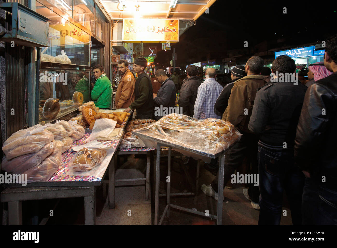 Jordanian men stand in line to buy bread in a bakery King Faisal street
