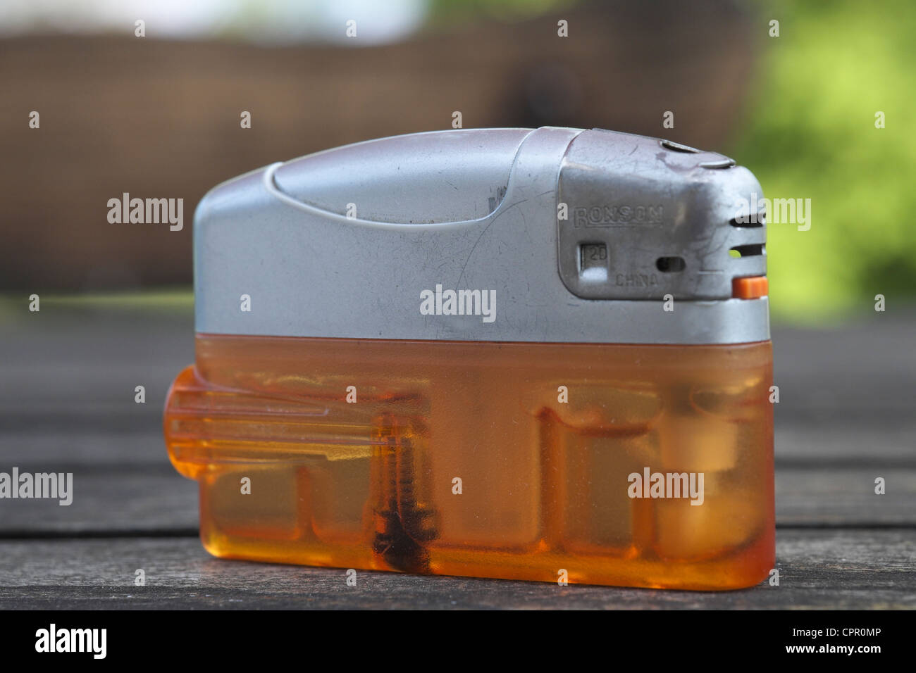 An used orange plastic Ronson lighter on a wooden table Stock Photo Alamy