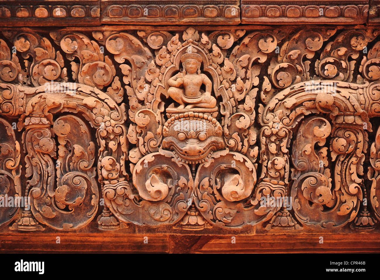 Ornate sandstone carvings on a lintel of the Banteay Srey temple complex in Siem Reap, Cambodia. This carving features a kala. Stock Photo