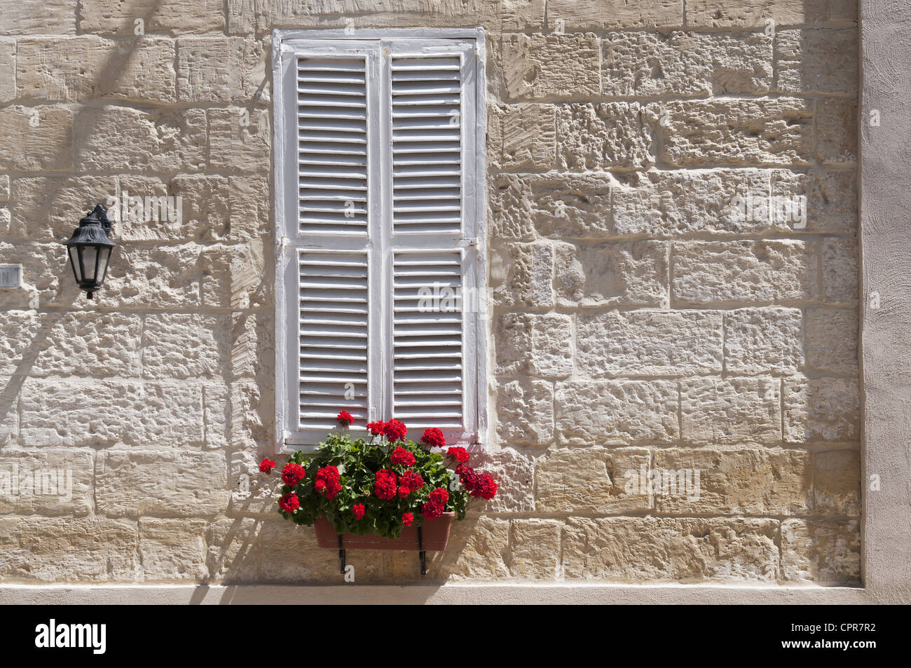 Deterorating window with white shutters in Sliema, Malta Stock Photo