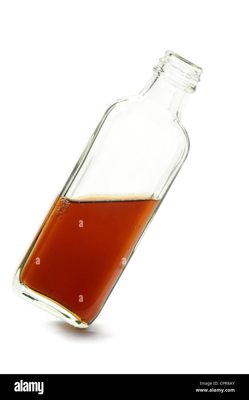 medicine bottle with brown liquid leaning to the right on white