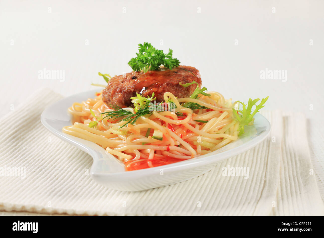 Meat patty with spaghetti and spicy sauce Stock Photo