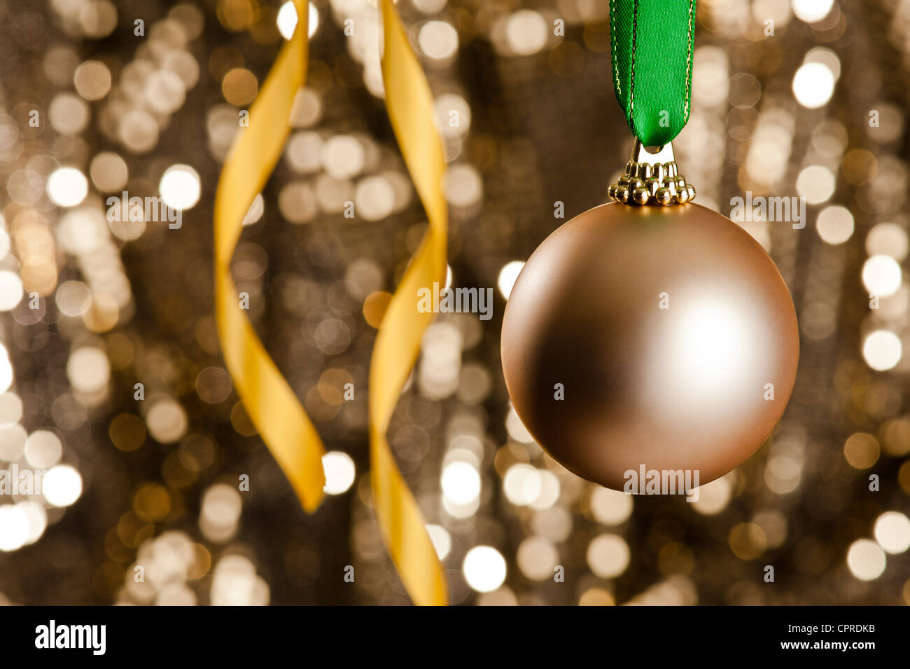 Single gold Christmas bauble in front of a gold glitter background for ...