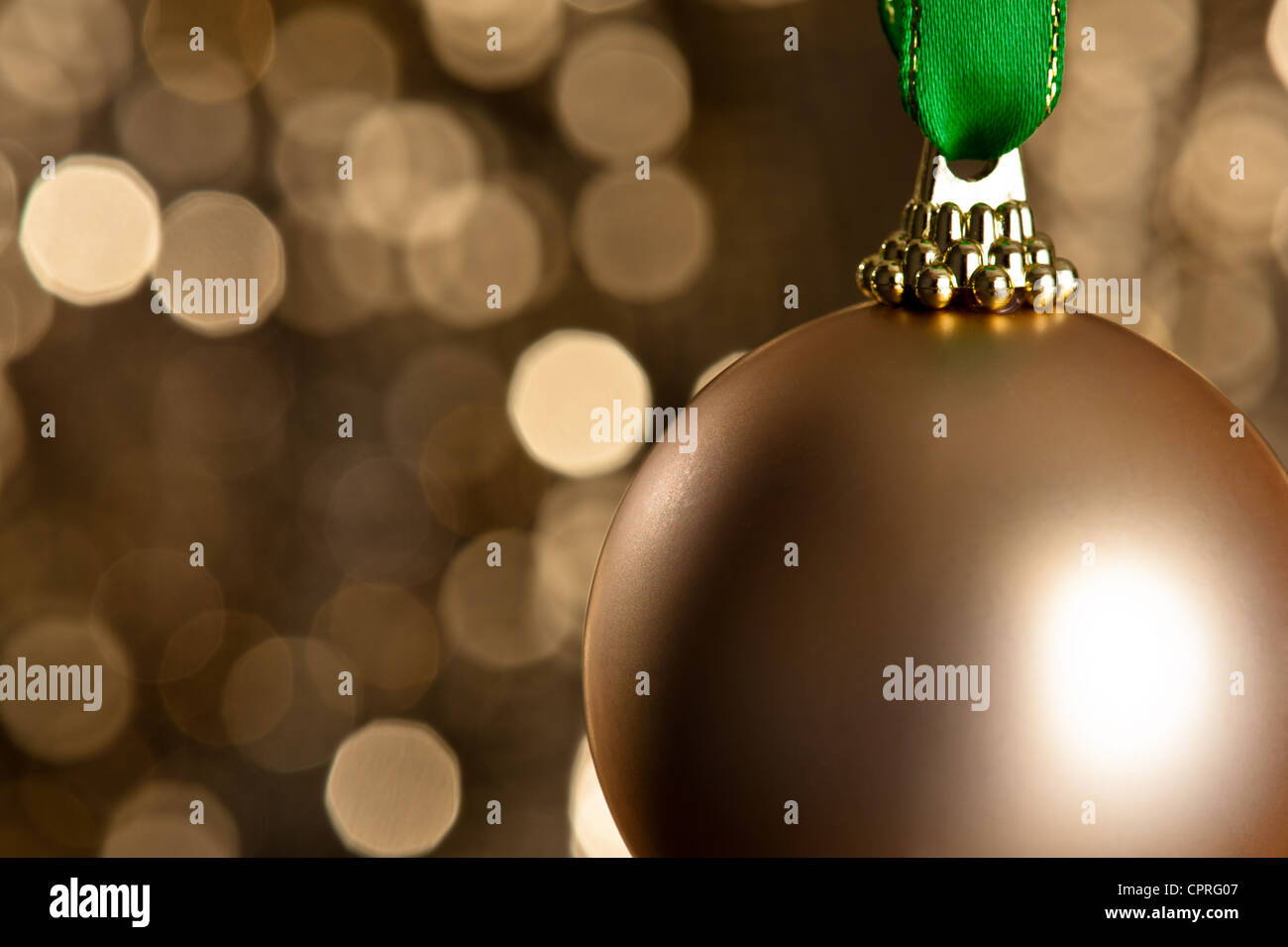 Single gold Christmas bauble in front of a gold glitter background for ...