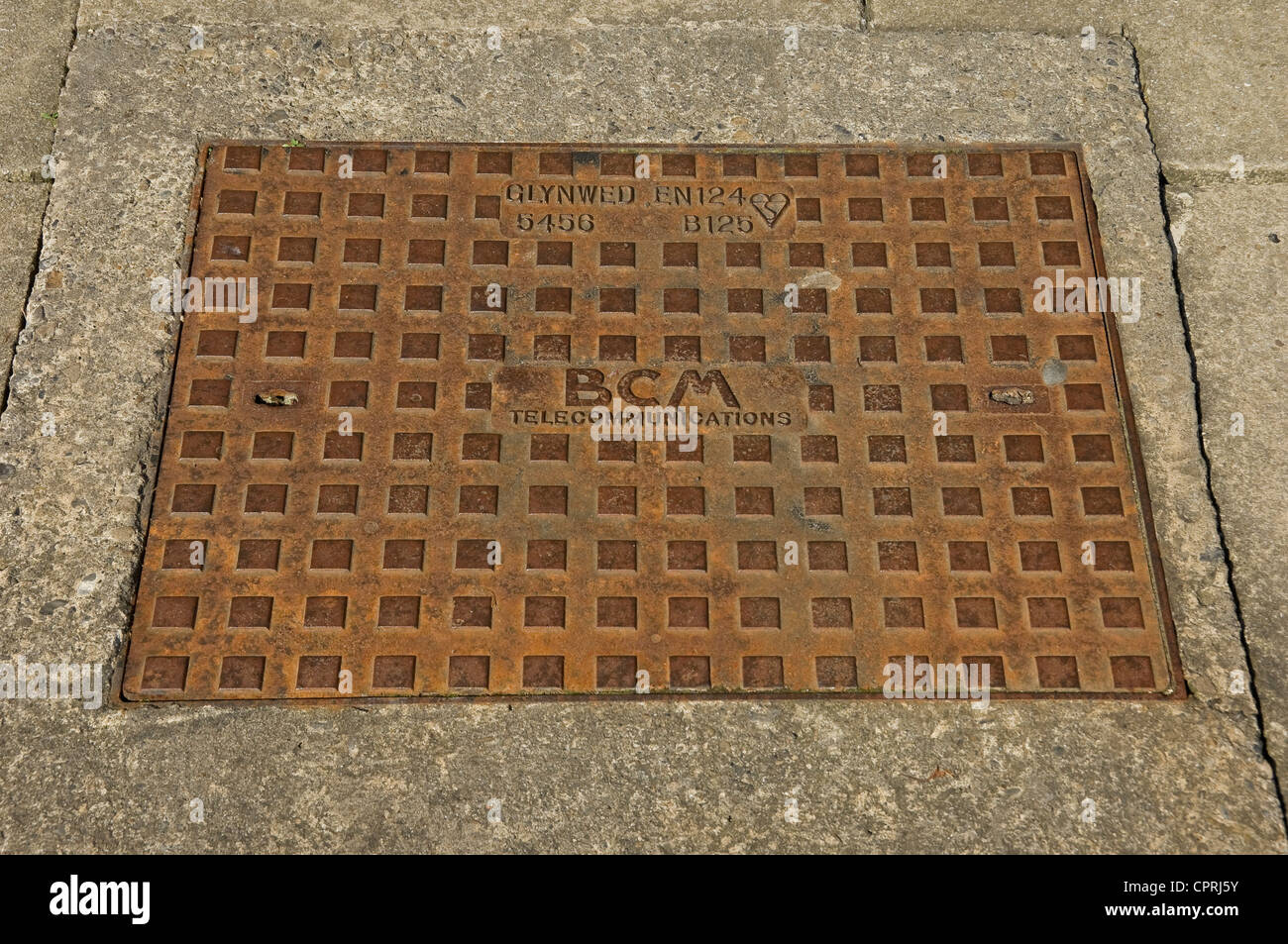 Close up of manhole cover set in pavement England UK United Kingdom GB Great Britain Stock Photo