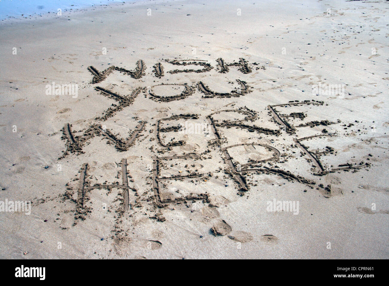 Message written into the sand on a beach, 'Wish you were here'. Stock Photo