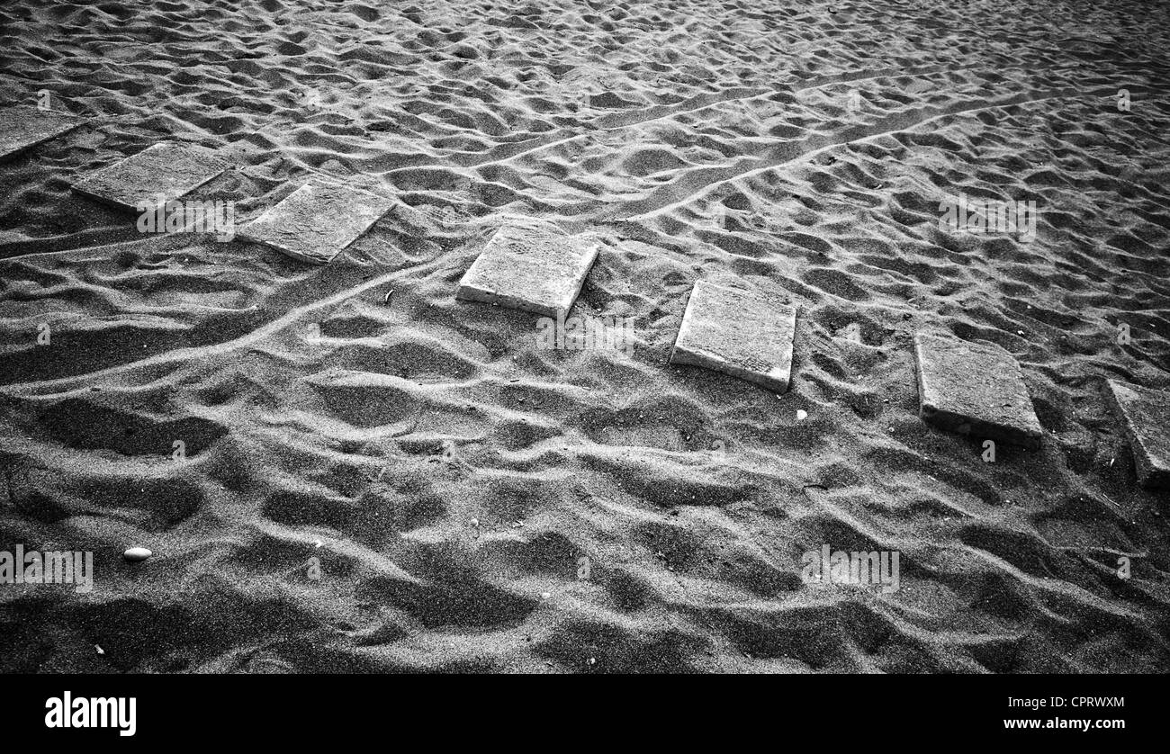 Abstract composition: beach lane made of seven flat concrete blocks in the sand Stock Photo