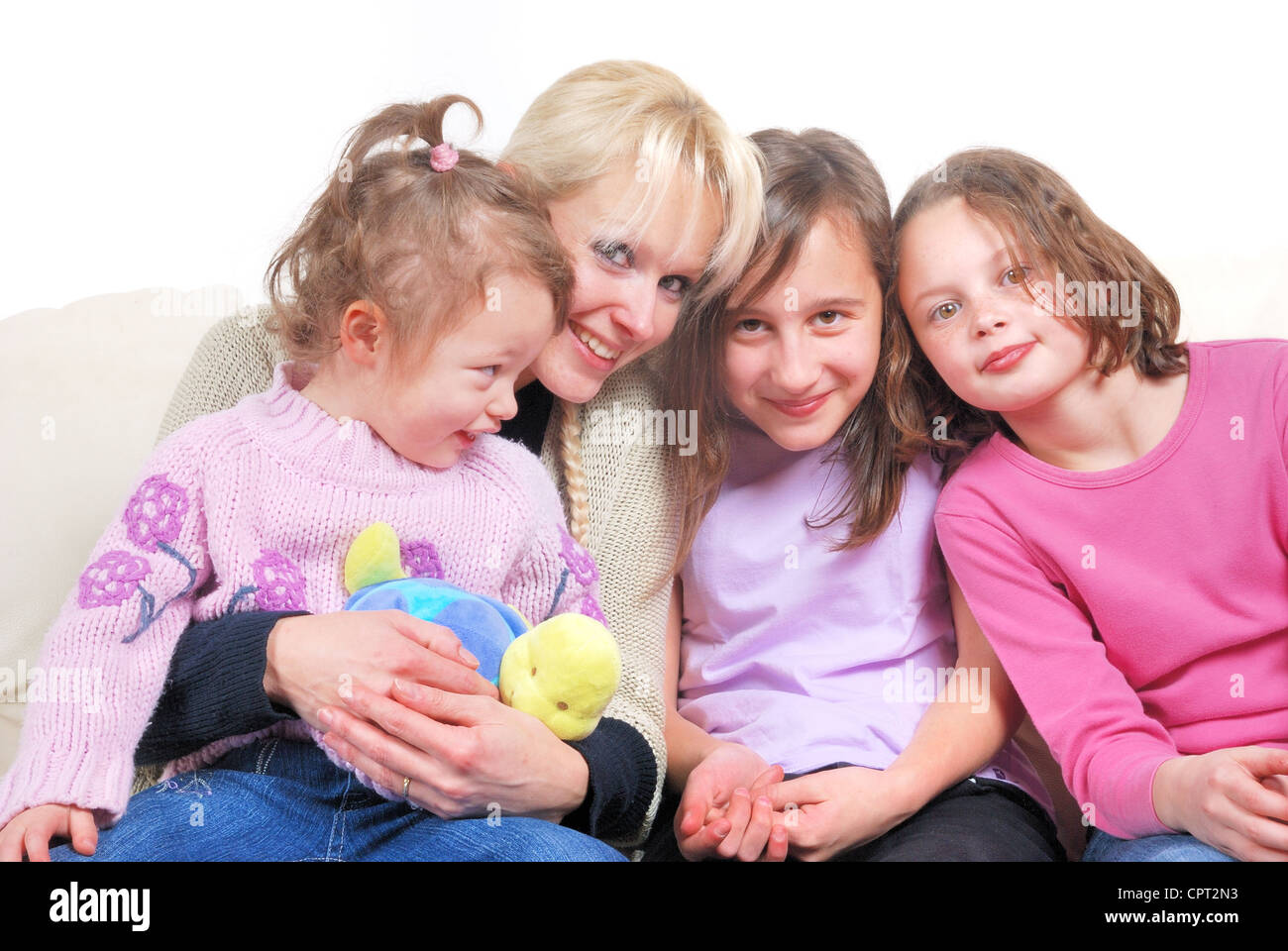 Family sitting in living room on sofa Stock Photo