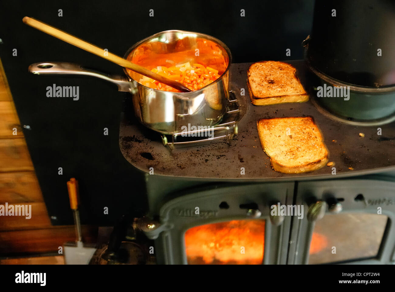 Cooking baked beans on toast on a wood fired stove, Wales Stock Photo Alamy