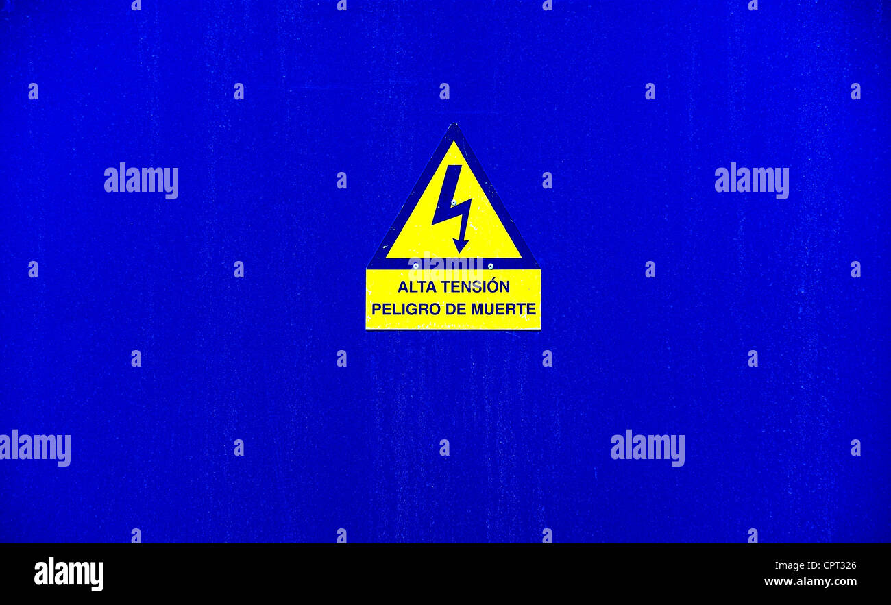 alta tension peligro de muerte hazard sign on blue background translates as threatening high voltage menorca spain Stock Photo