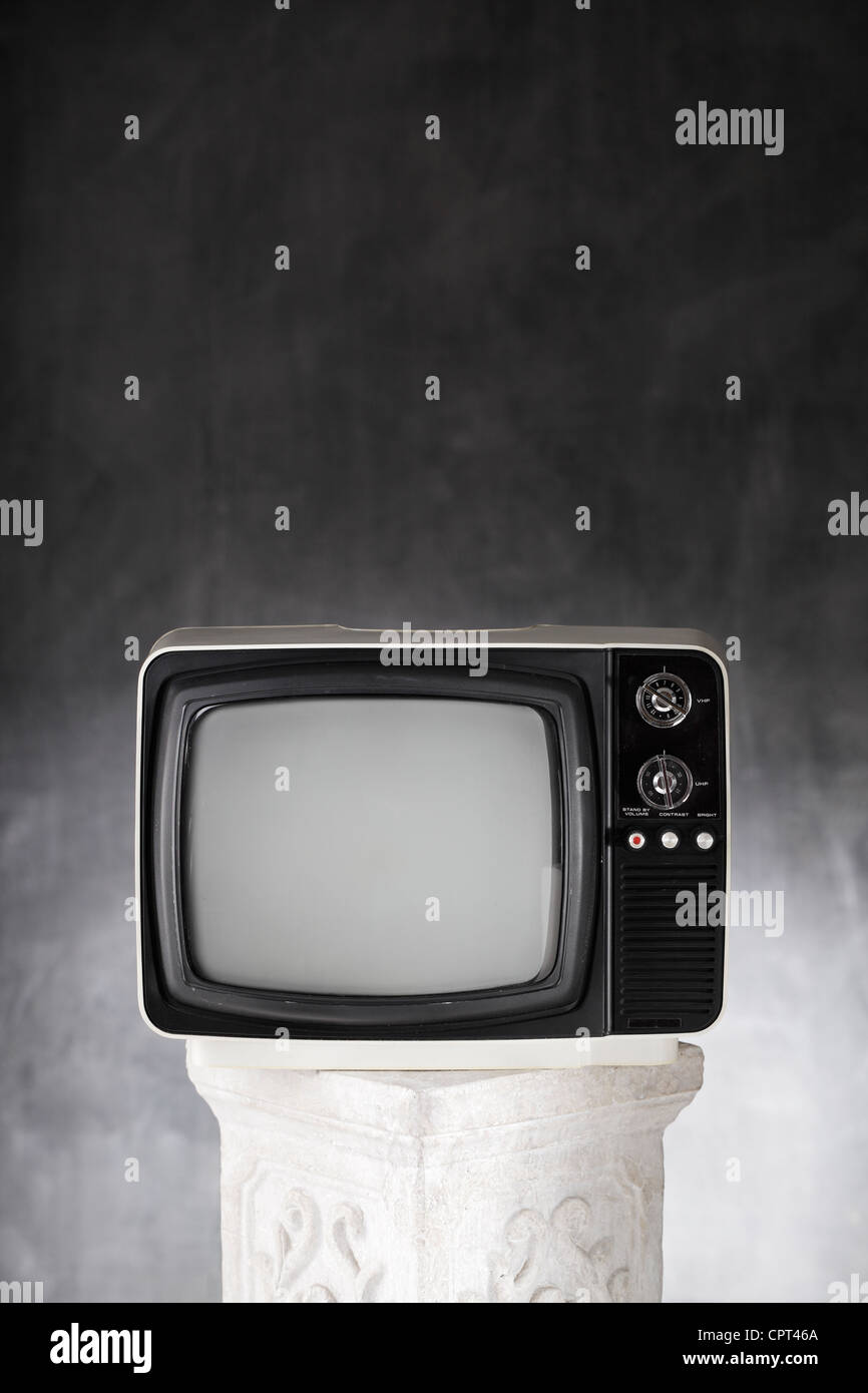 Old small portable television on a plaster column. Stock Photo
