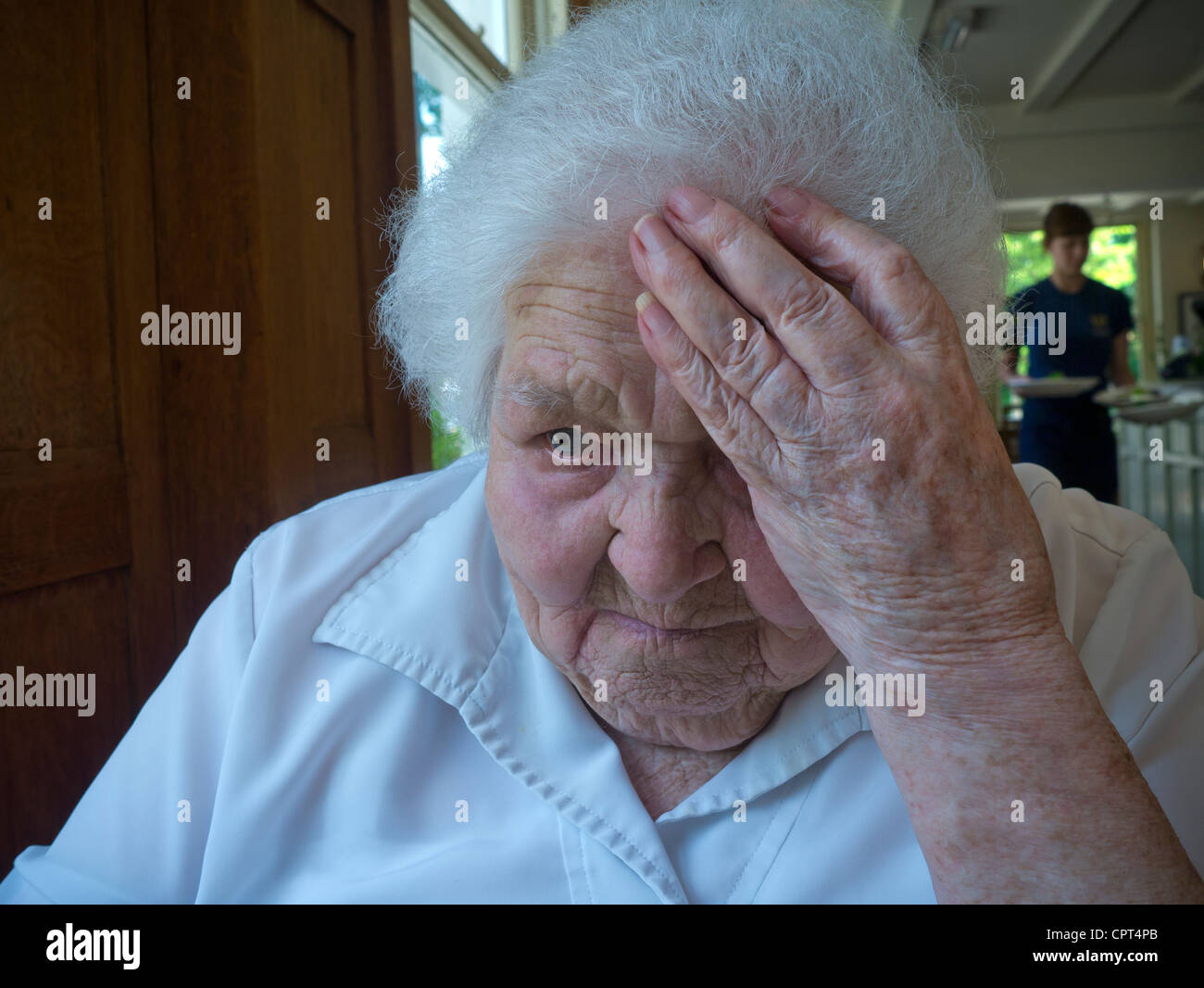 ELDERLY OLD MEALS CARE ROOM FOOD Apprehensive sad worried vulnerable senior elderly old age lady in large dining room old people’s home care facility Stock Photo