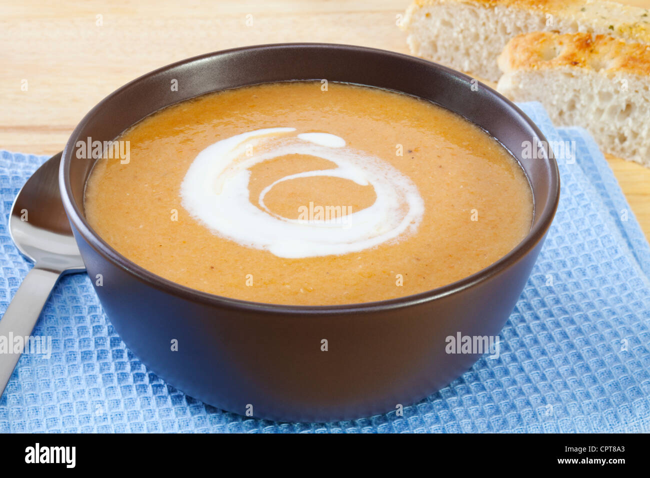 A bowl of homely lentil and carrot soup, swirled with yoghurt. Stock Photo