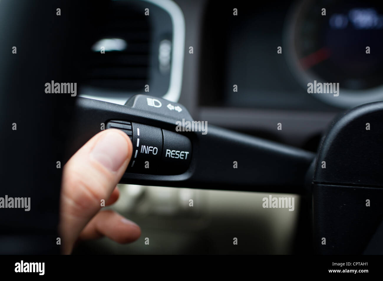 Modern car interior driver pressing a button, using the car computer