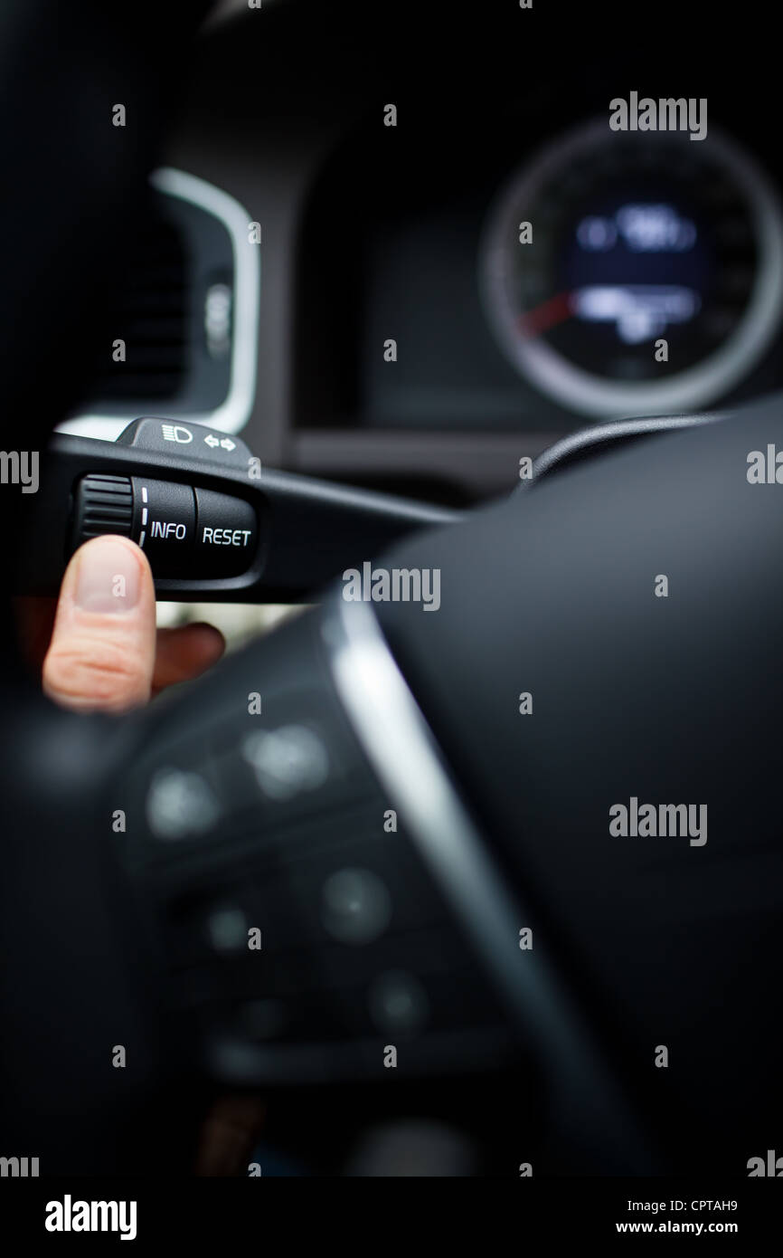 Modern car interior driver pressing a button, using the car computer