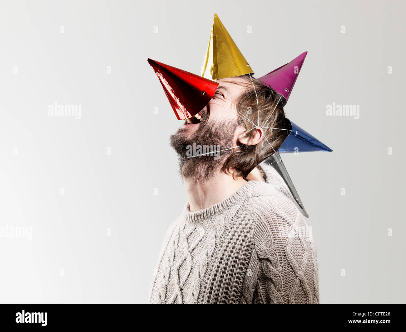 Mid adult man in party hats against white background Stock Photo