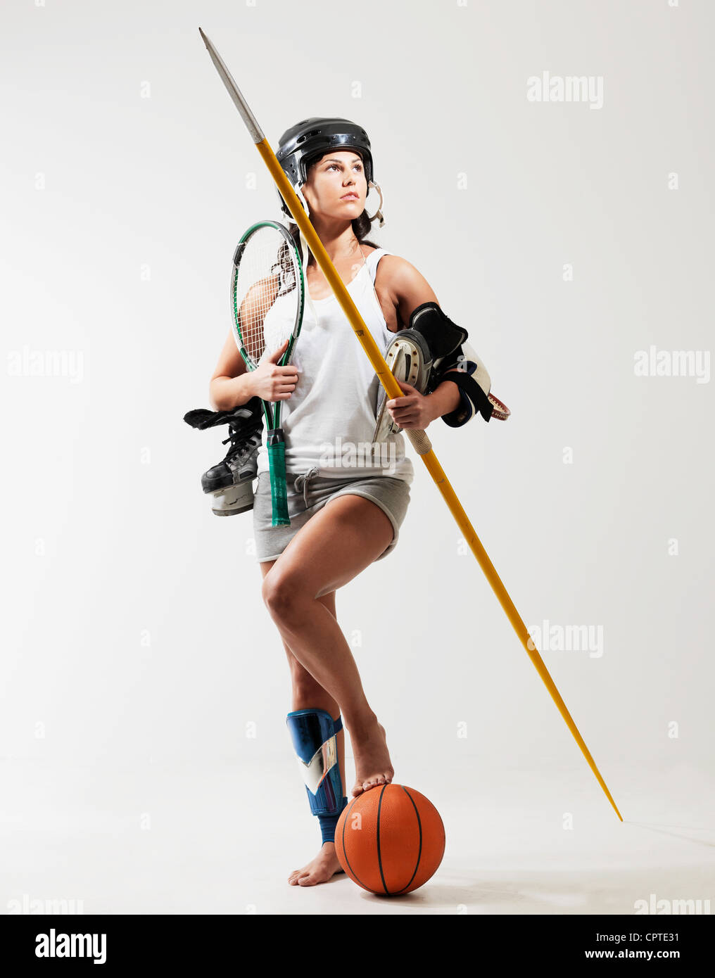 Young woman holding sports equipment against white background Stock Photo