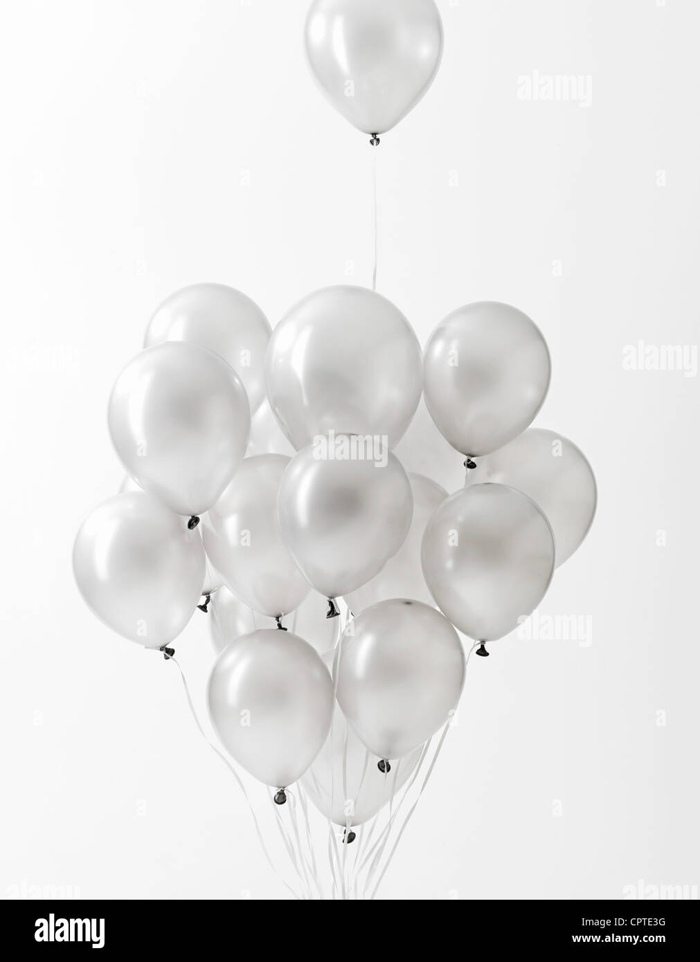 Silver balloons floating against white background Stock Photo