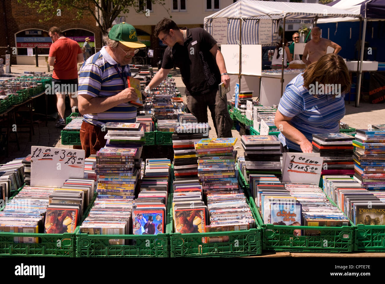 People perusing CD/DVD stall at the weekly outdoor market, Petersfield, Hampshire, UK. Stock Photo