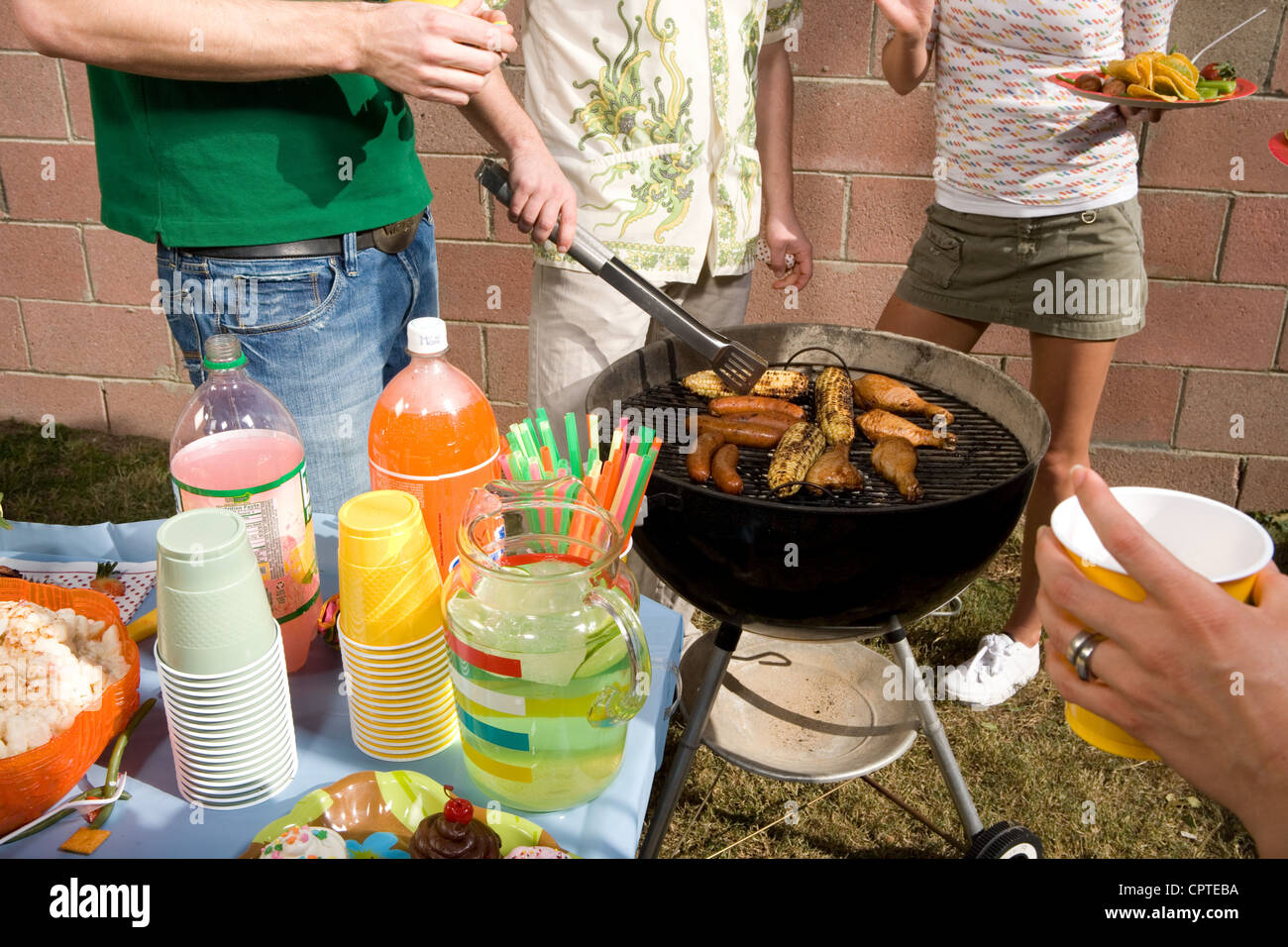 Man cooking with friends at barbecue Stock Photo