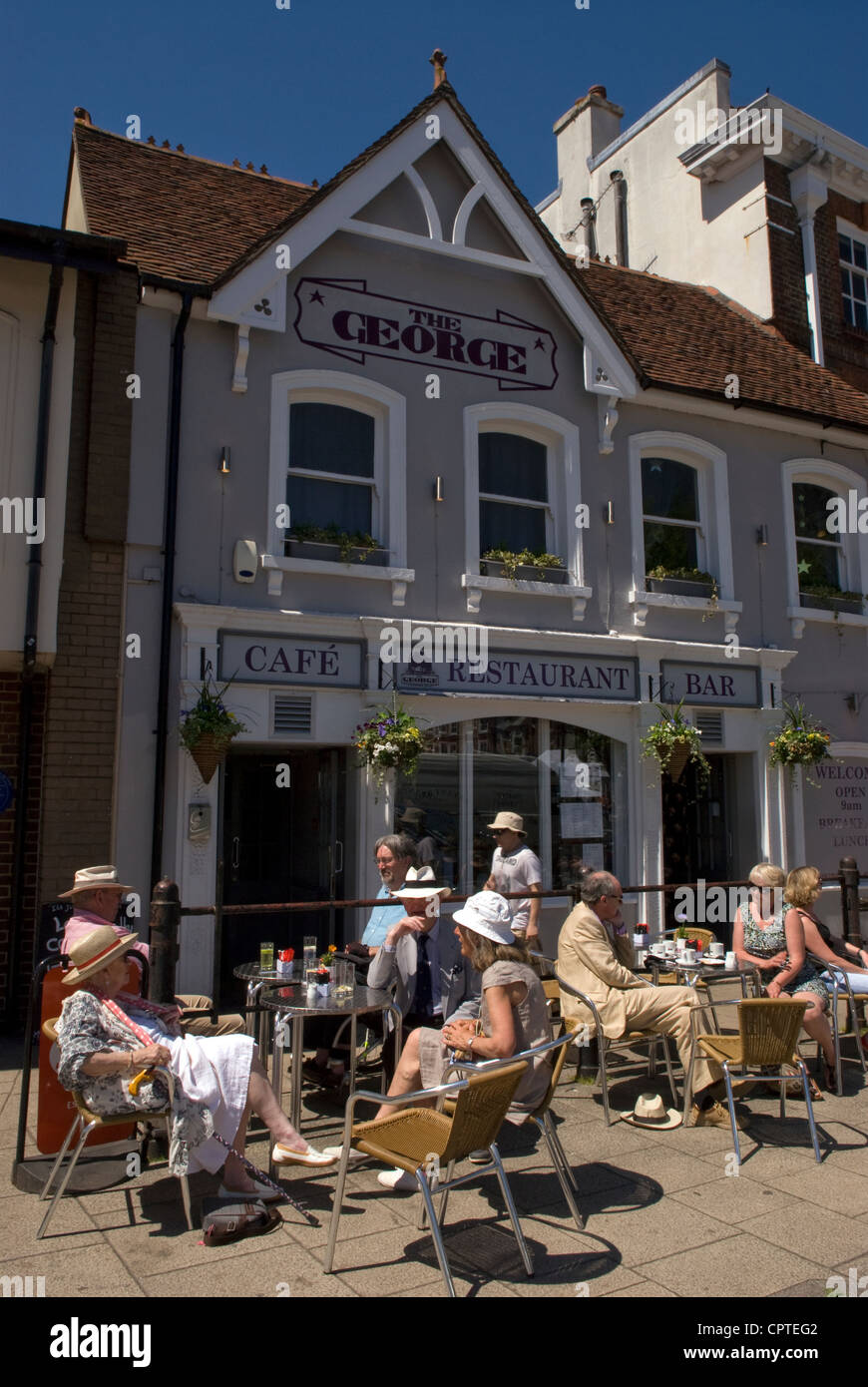 People enjoying a relaxing summer's day drink outside The George public house, Main Square, Petersfield, Hampshire, UK. Stock Photo