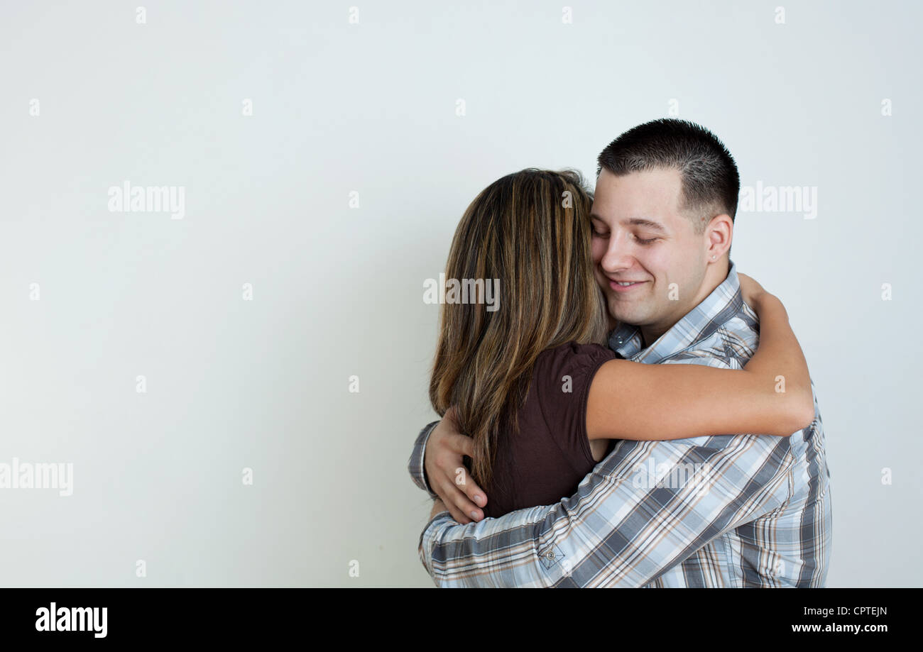 Mixed race couple embracing, studio shot Stock Photo