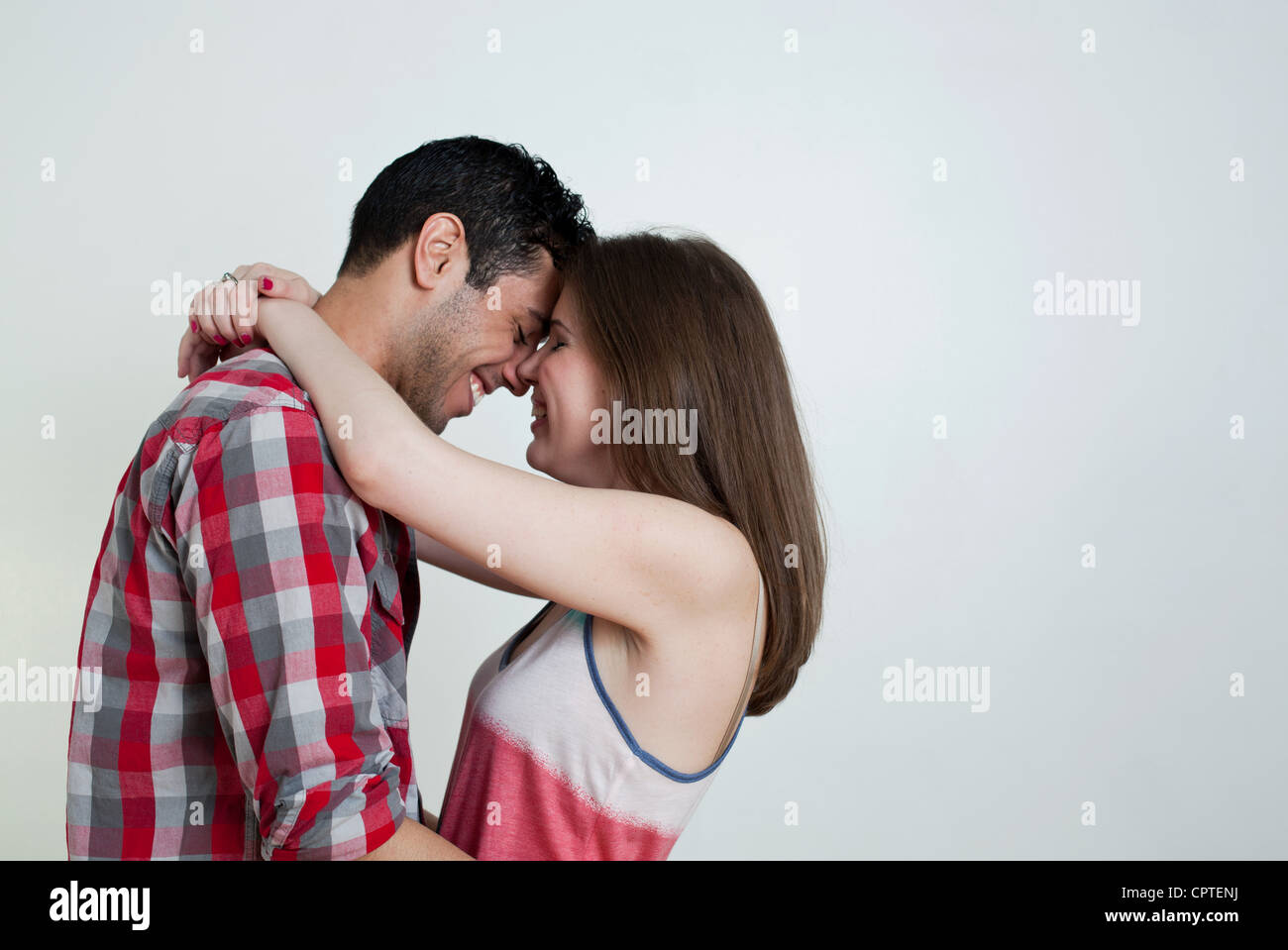 Young couple embracing, studio shot Stock Photo