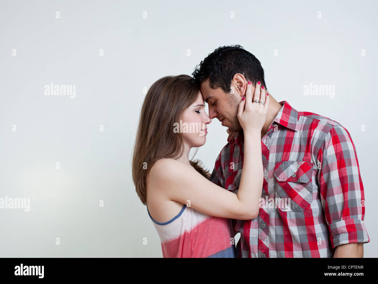 Young couple embracing, studio shot Stock Photo