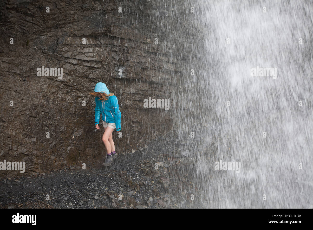 Child walking behind a waterfall in the Trafoi Valley, Italy Stock Photo