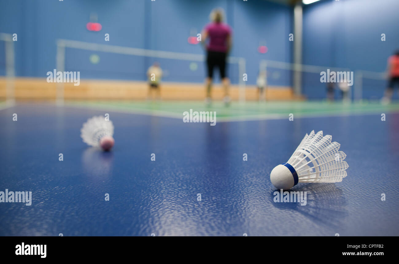 badminton badminton courts with players competing; shuttlecocks in