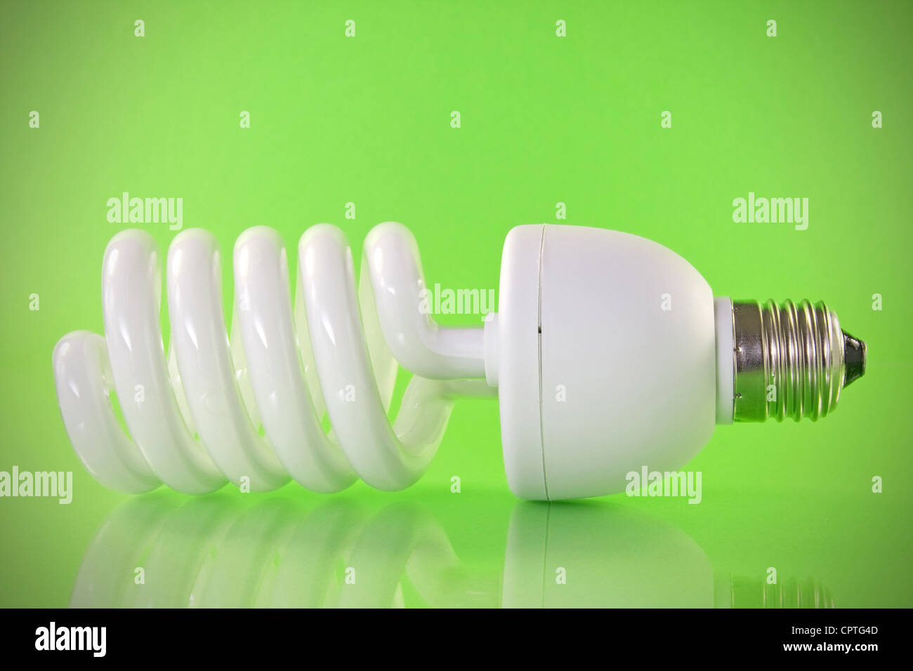 Energy efficient light bulb on green background Stock Photo - Alamy