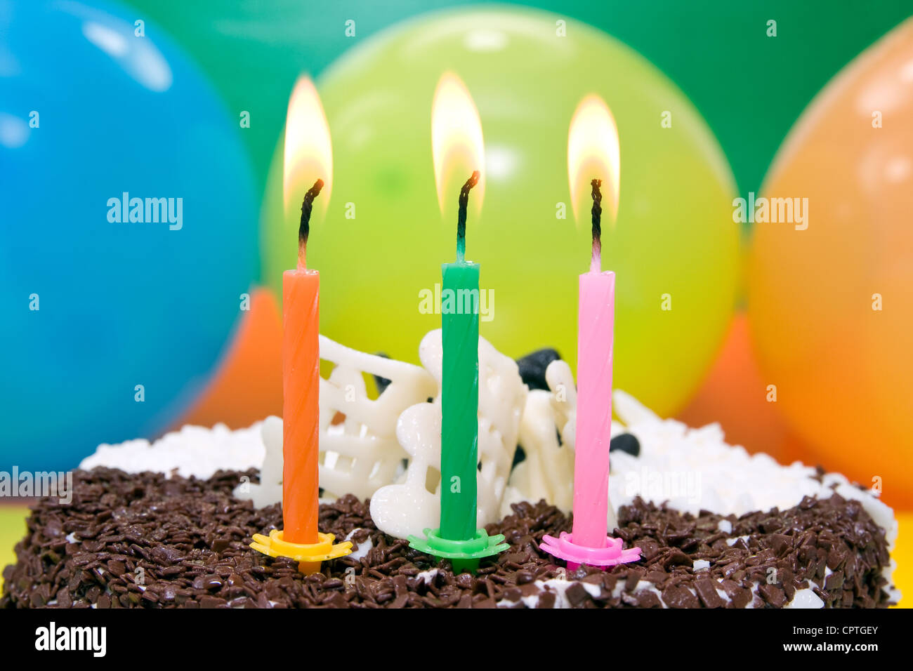 happy birthday cake with three color candles Stock Photo Alamy
