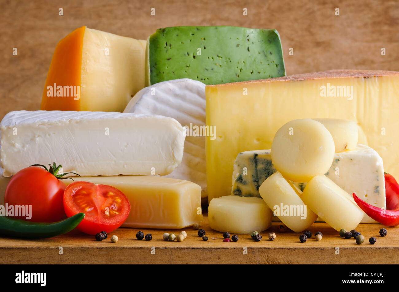 Background with gourmet cheese on a wooden table Stock Photo