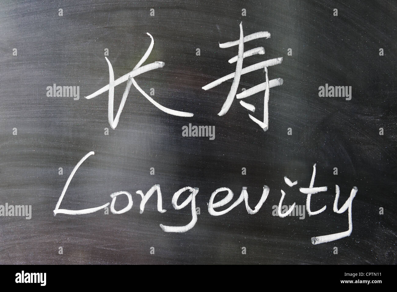 Longevity word in Chinese and English written on the chalkboard Stock Photo