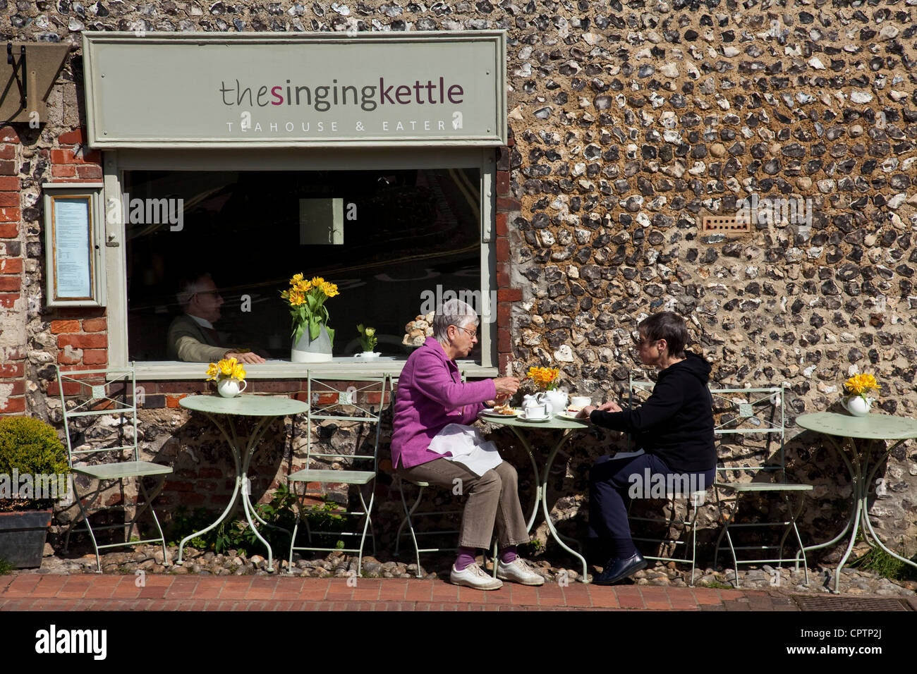 Two women enjoying tea outside The Singing Kettle Cafe, Alfriston