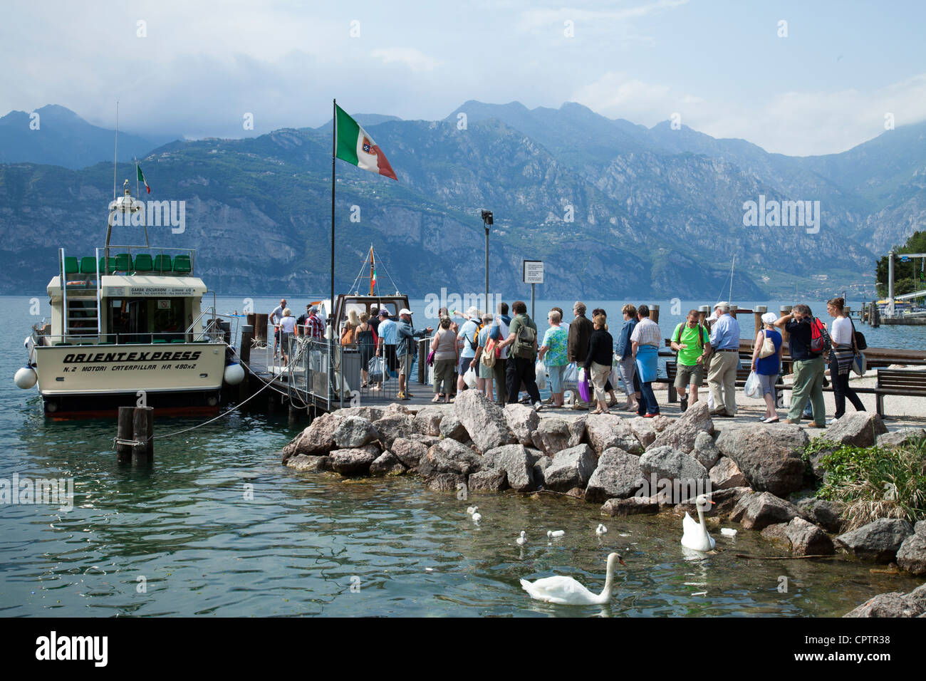 A group of tourists waiting to board an Italian tourist boat Lake Garda Italy Stock Photo