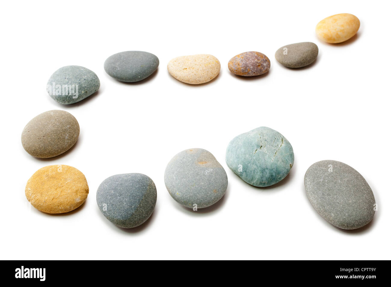 Snaking line of twelve coloured pebbles isolated on white. Clipping path for stones. Stock Photo