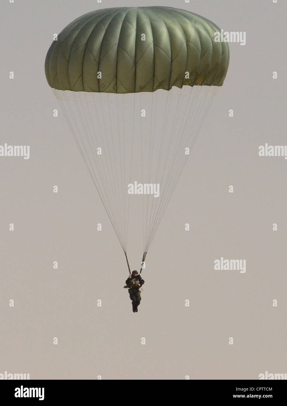 Jordanian soldier parachutes safely into the drop zone after completing his static line jump at the Exercise Eager Lion 2012 friendship jump to help kick start the multilateral exercise. The focus of Eager Lion 2012 is to strengthen military-to-military relationships of participating partner nations. The friendship jump is the first step in accomplishing this goal as parachutists from Combined Joint Task Force Spartan jumped together. Stock Photo