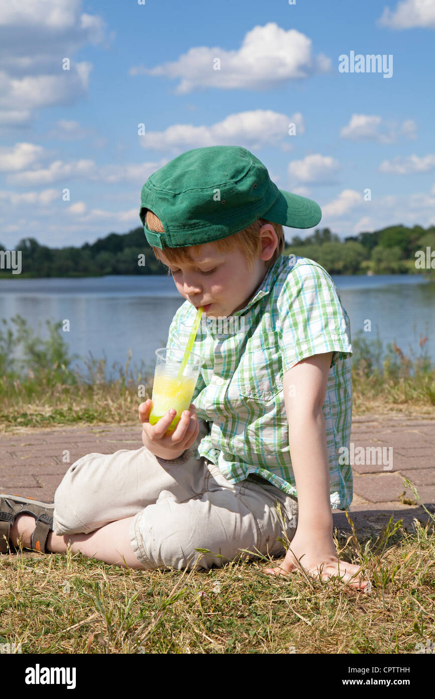 young boy eating ice-cream beside Lake Gartow, Gartow, Lower Saxony, Germany Stock Photo