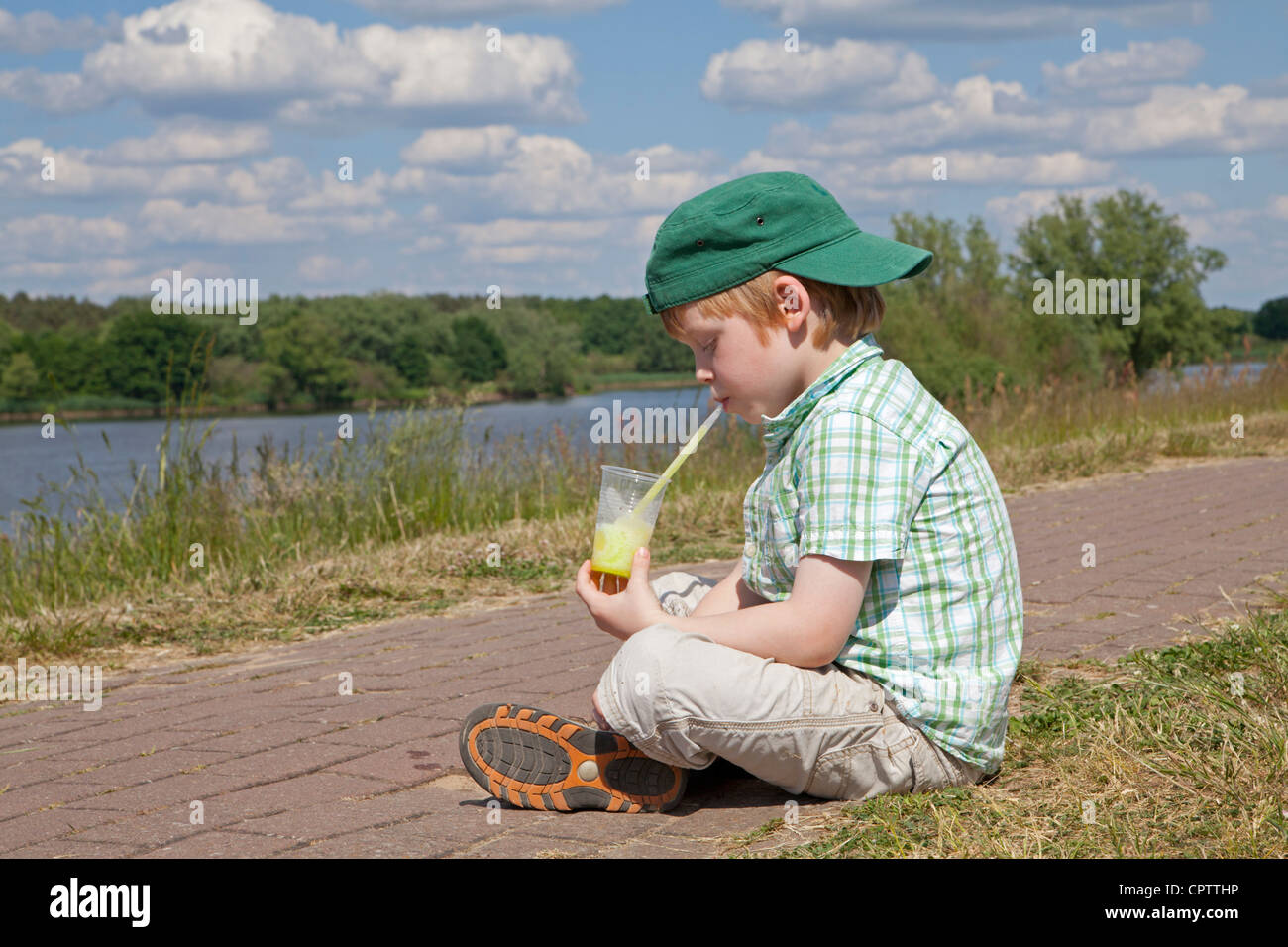 young boy eating ice-cream beside Lake Gartow, Gartow, Lower Saxony, Germany Stock Photo