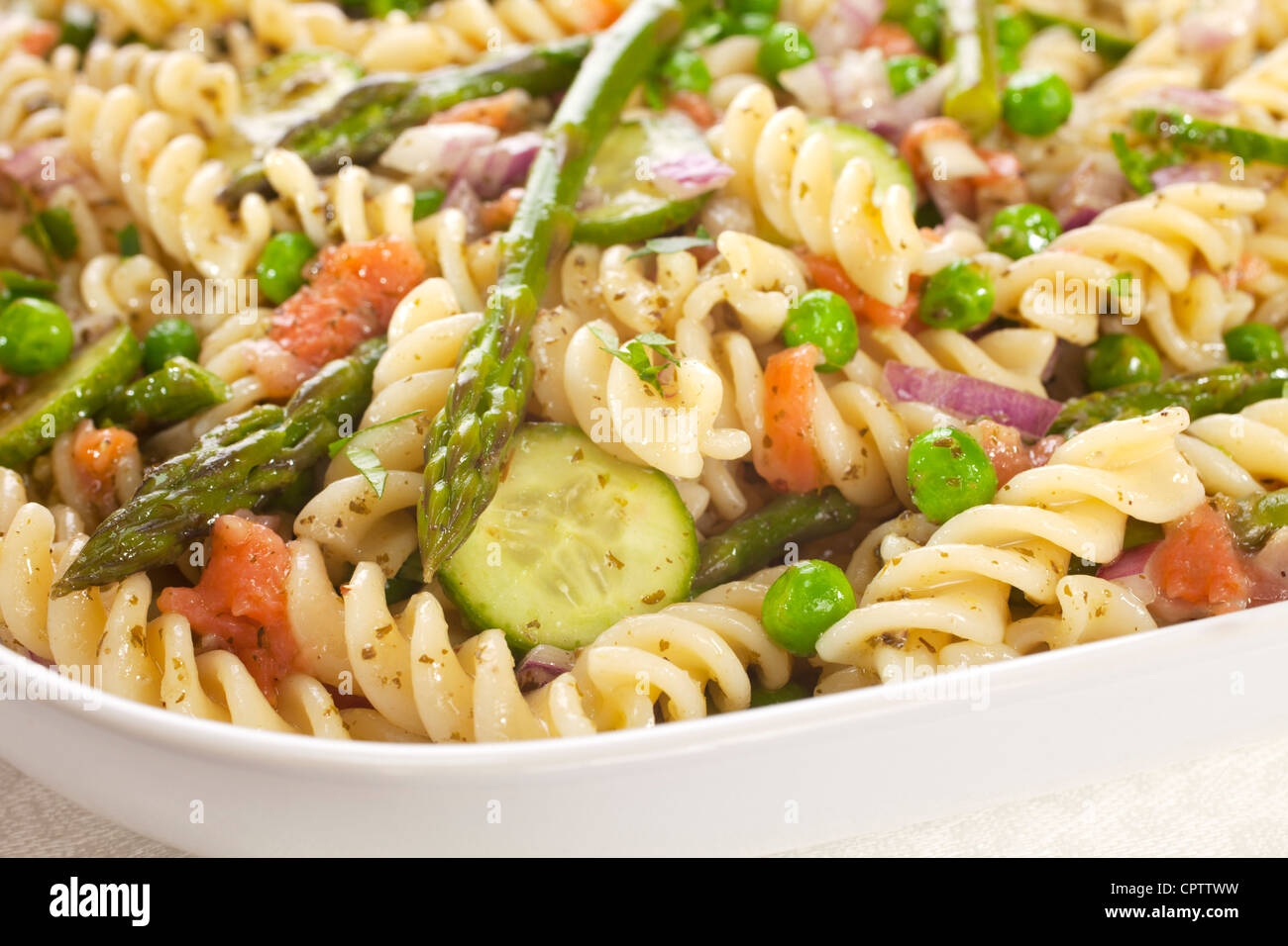 Pasta salad made with asparagus, peas, red onion, cucumber and scraps
