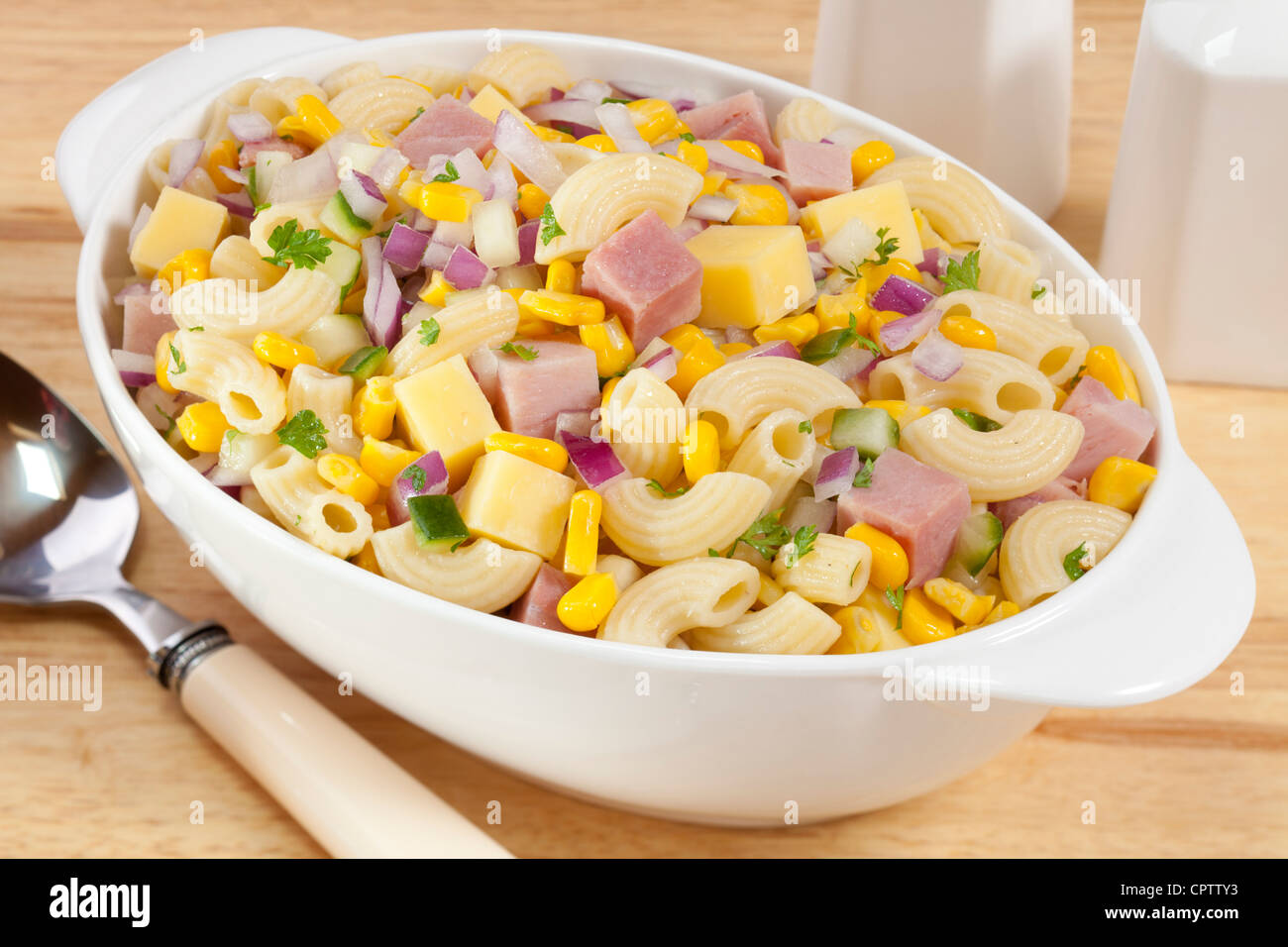 Macaroni salad with ham, cheese, corn, red onion and cucumber. Stock Photo