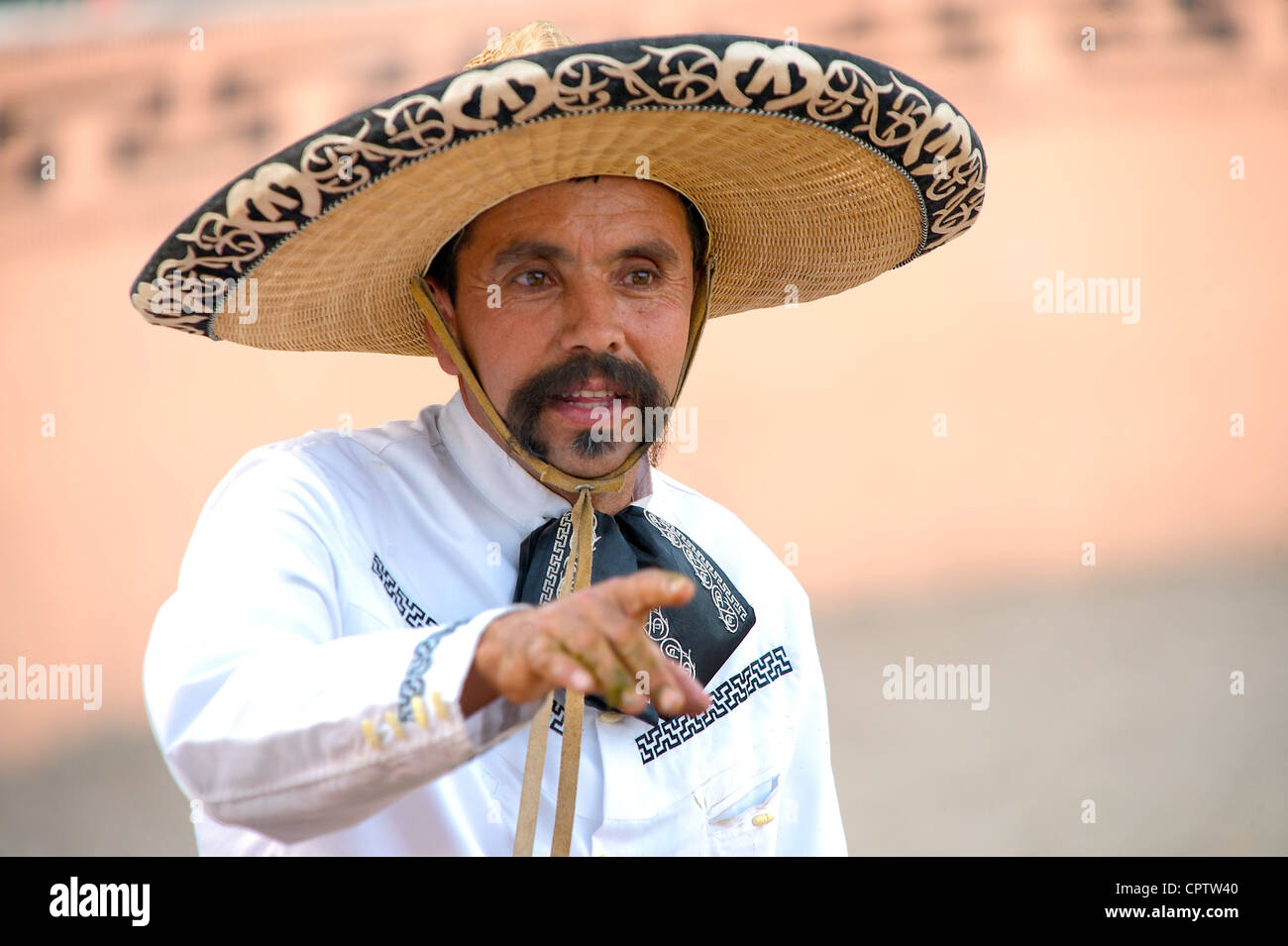 Mexican charro (horseman) pointing during a break in a charreada, San Antonio, TX, US Stock Photo