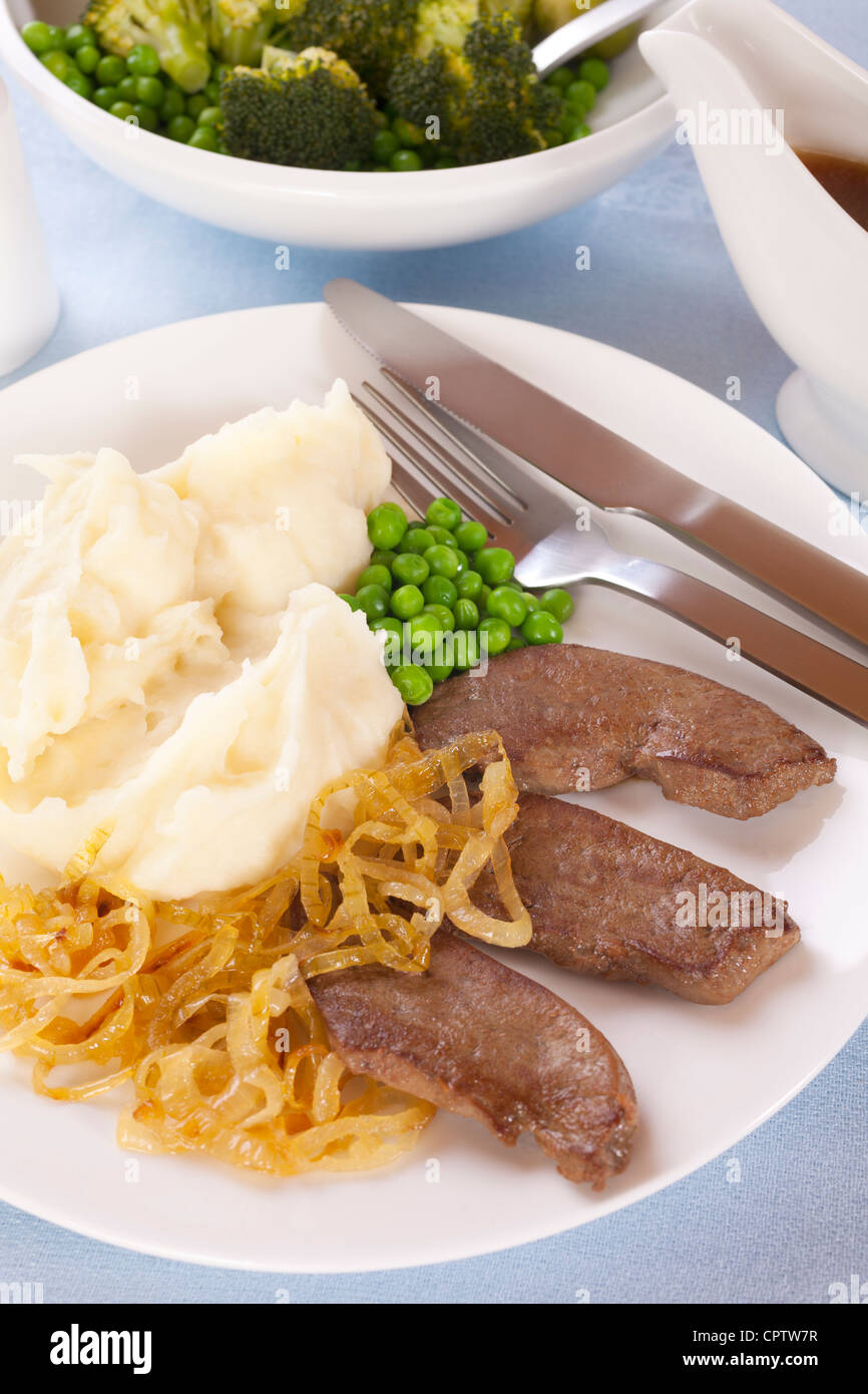 Liver with caramelised onions, mashed potatoes and green vegetables. Stock Photo