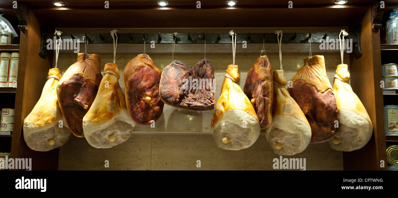 Shop window display of cured meats, hams, pork shoulders, at Dalmayr food shop and delicatessen in Munich, Bavaria, Germany Stock Photo
