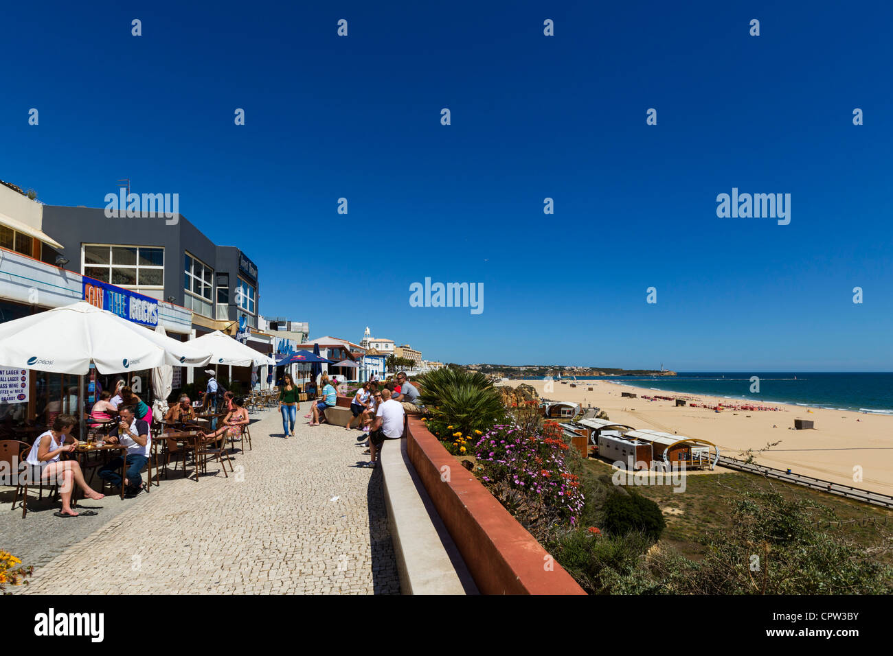 Bars and cafes on seafront promenade overlooking main beach in  centre of resort of Praia da Rocha, Portimao, Algarve, Portugal Stock Photo