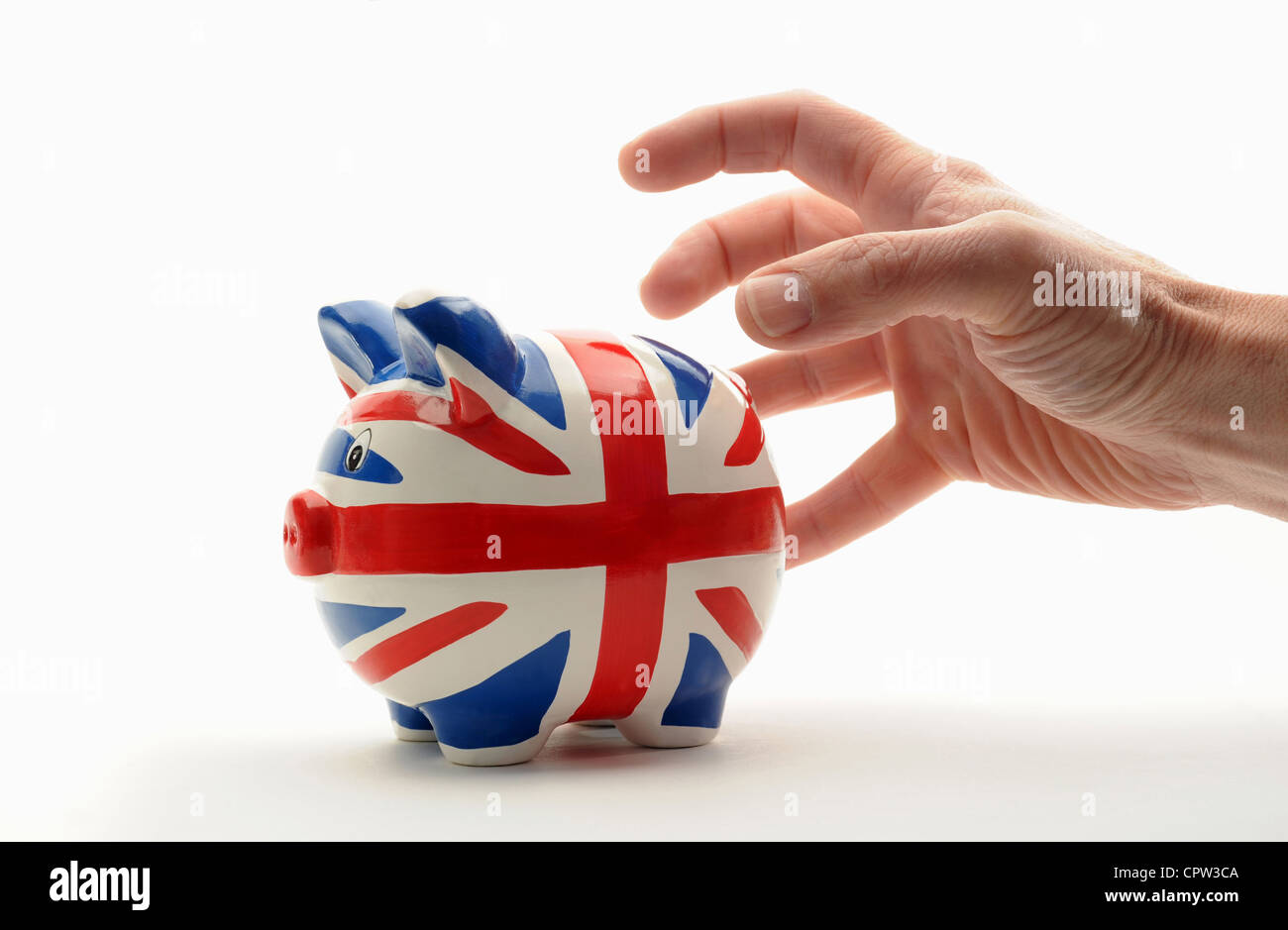BRITISH PIGGYBANK PIGGY BANK BEING GRABBED BY MANS HAND RE THE ECONOMY SAVINGS INCOMES WAGES HOUSEHOLD BILLS BANKS BANKING UK Stock Photo