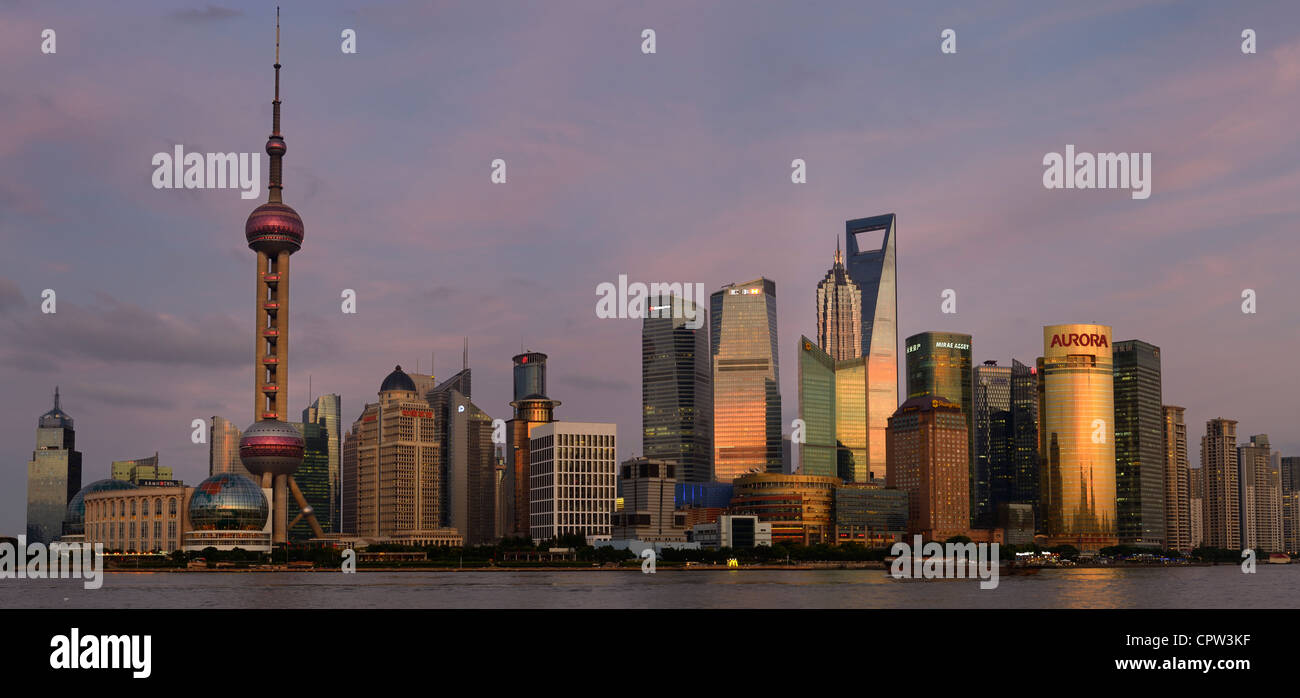 Panorama of pink sky and dusk light on high rise financial towers and hotels in the Pudong east side of Shanghai skyline Peoples Republic of China Stock Photo